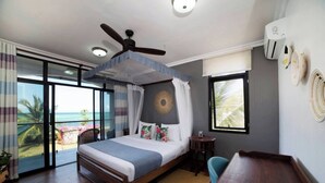 A bedroom with a bed, a ceiling fan, a view of the ocean, and a balcony. - Zanzibar Beachfront Villa 1012 (Zanzibar)
