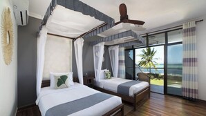 A room with two beds, a ceiling fan, and a large window with a view of the ocean. - Luxury Beachfront Bliss Awaits in Zanzibar (Zanzibar)