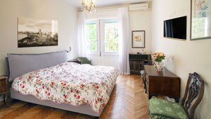 Un dormitorio con una cama grande, un aparador de madera, una silla y un escritorio.
