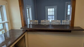 A kitchen with a granite countertop, white cabinets, and a window with a view of trees. - 2-bedroom apartment with balcony view and walking distance balloon rally (Wellsville)