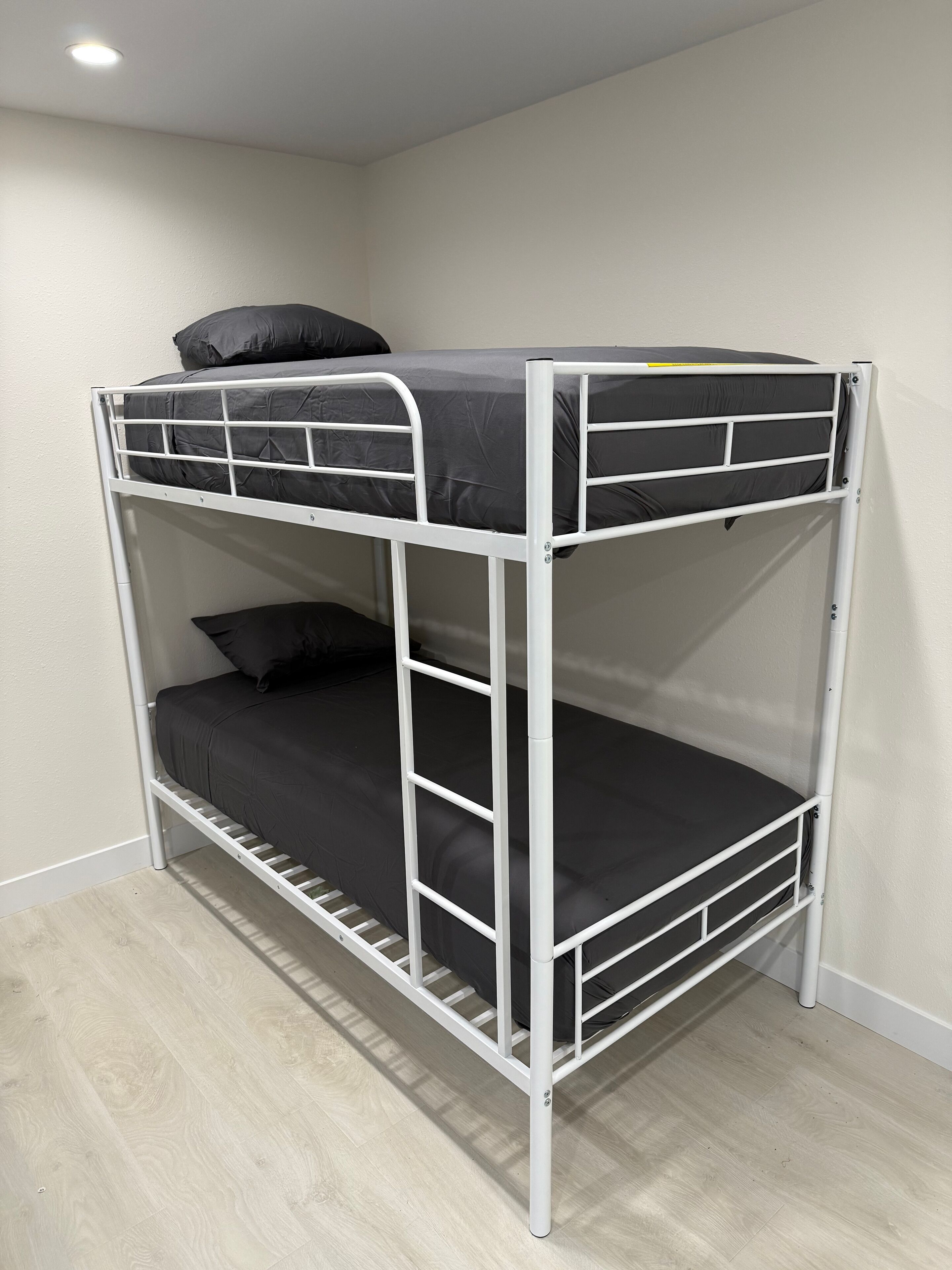 A bunk bed with a metal frame and black bedding.