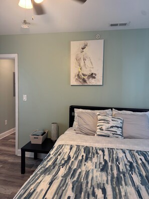 A bedroom with a bed, a bedside table, a wall-mounted artwork, and a ceiling fan. - Charming 2-bedroom apartment with WiFi, AC in delightful Philadelphia (Philadelphia)