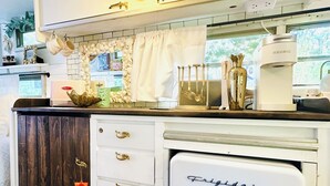 A compact kitchenette with a white Frigidaire refrigerator, a coffee maker, and a small sink.