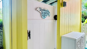 A yellow and white building with a sign reading "Showers $1.00 To Watch $2.00".