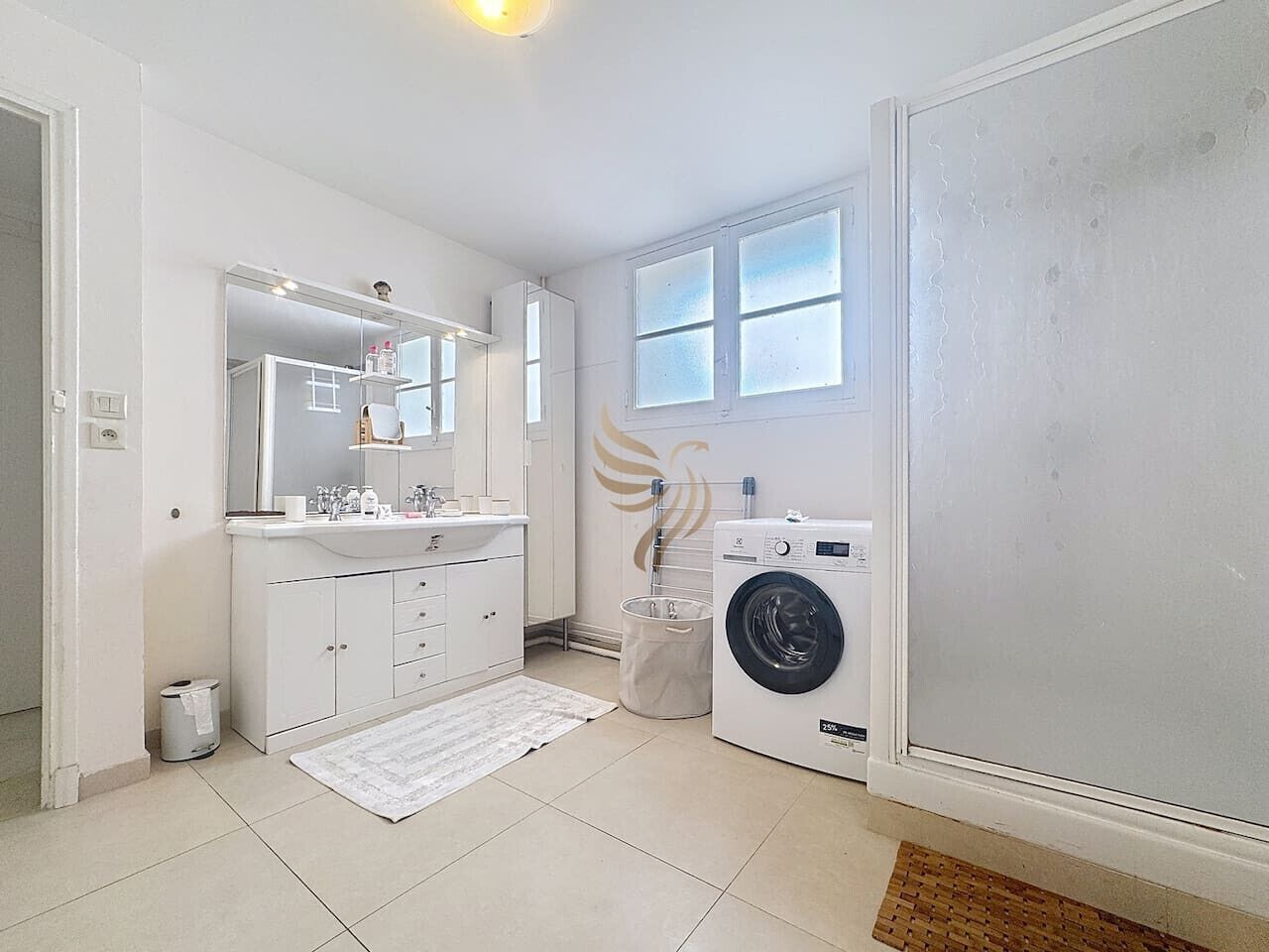 Ein modernes Badezimmer mit Waschbecken, Spiegel und Waschmaschine.