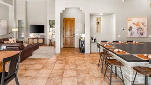 Amplia sala de estar con chimenea, una gran mesa de comedor y una zona de bar.