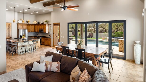 Una cocina amplia con comedor, ventanas grandes y vista a una piscina.