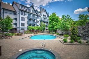 A hotel with a swimming pool, outdoor seating, and a stone wall. - Bright retreat w/ hot tub & resort access (Stratton Mountain)