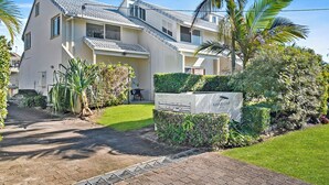 A modern two-story house with a paved driveway and a well-maintained lawn. - Beachside Townhouse (Sunrise Beach)