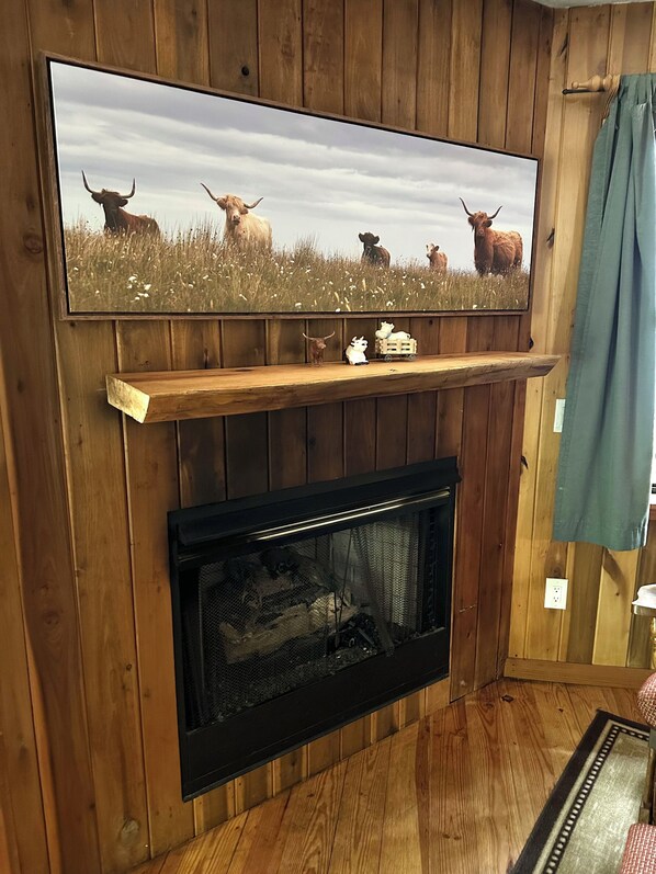 Una chimenea con un televisor montado encima, dentro de una habitación de madera.