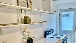 A kitchen with white cabinets, a countertop, a stove, and a door with a window. - Charming Entire Main Floor with WiFi in downtown Hawley (Hawley)