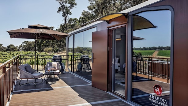 A deck with outdoor seating, a grill, and a glass door leading to a room. - Aravina Escapes (Yallingup)