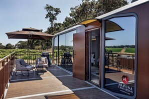A deck with outdoor seating, a grill, and a glass door leading to a room. - Aravina Escapes (Yallingup)