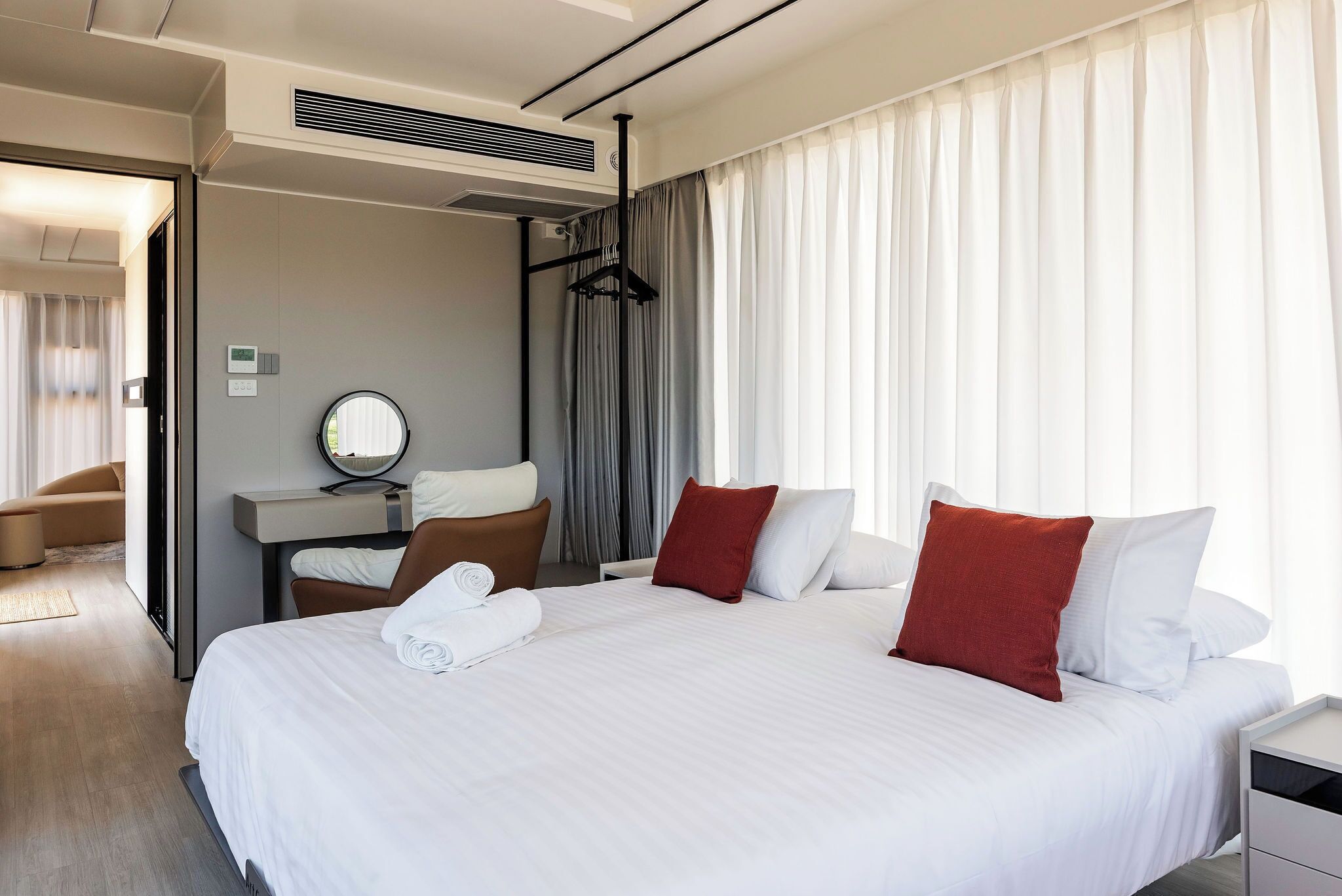 Una habitación de hotel con una cama grande, un escritorio, una silla y un espejo.