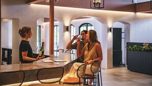A modern interior with a bar area, seating, and a fireplace. - Aravina Escapes (Yallingup)