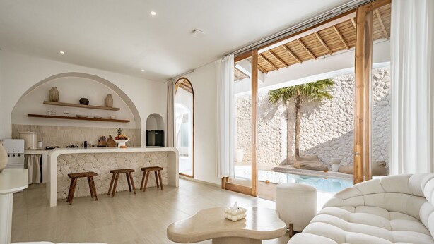 A modern kitchen with a stone backsplash, wooden stools, and a bar area. - Villa Estrella Seseh (Munggu)