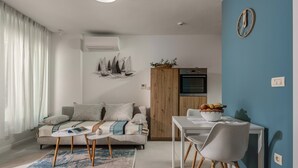 Ein modernes Wohnzimmer mit Sofa, Couchtisch und Essbereich.