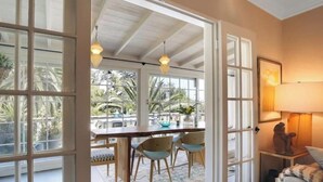 A room with a large window, a wooden dining table, and two chairs. - Riviera Gem - Designer decorated private 2BR home (Santa Barbara)