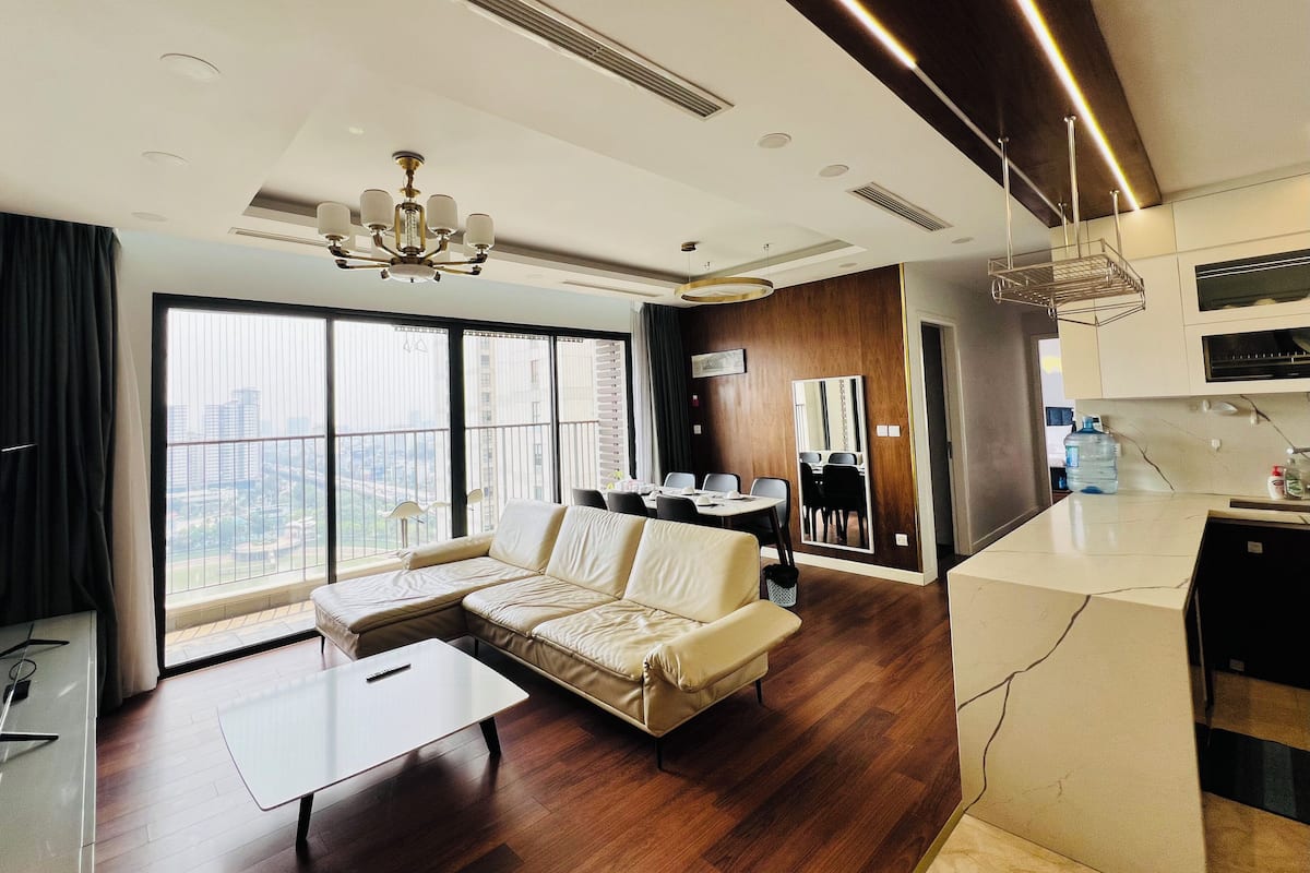 Une chambre d’hôtel moderne équipée d’un canapé, d’une table à manger et d’un coin cuisine.