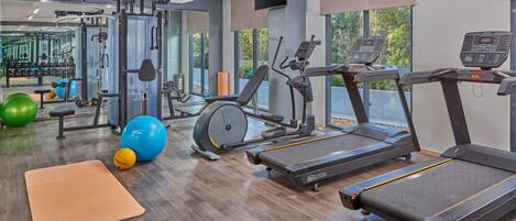 A gym with treadmills, exercise balls, and weight machines.