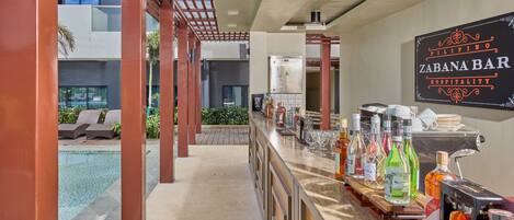 A bar area with a pool view, a sign for 'Filipino Zabana Bar Hospitality', and a variety of liquor bottles.