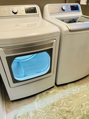 A front view of a front-loading washing machine and dryer side by side. - Historic Downtown Raleigh 3-bedroom Home Close to Everything (Raleigh)