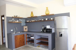 Kylskåp, mikrovågsugn, grytor/köksredskap och matbord
