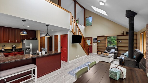 A spacious living area with a kitchen, a fireplace, a staircase, and a seating area.