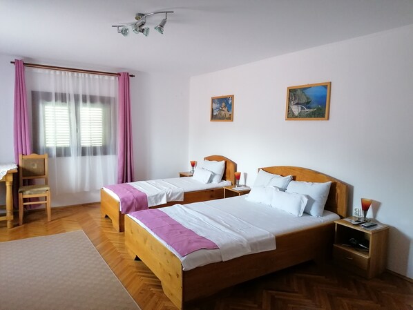 Ein Doppelbett mit Holz-Kopfteil, ein Nachttisch mit Lampe und ein Sessel.