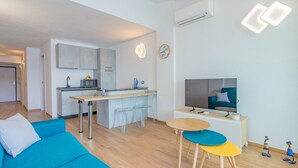A modern apartment with a kitchen, dining area, and living room. - Sea view apartment in Porto Azzurro (Porto Azzurro)
