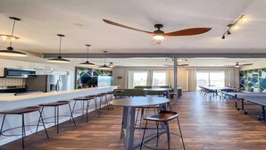 A spacious hotel lobby with a central bar area, multiple seating options, and ceiling fans. - Sojourn The Lighthouse  Beach Front Resort Villa (Norfolk)