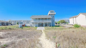 A beachfront property with a main house and a separate tower, featuring a sandy pathway leading to the entrance. - Sojourn The Lighthouse  Beach Front Resort Villa (Norfolk)