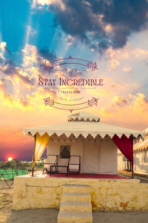 A tented structure with a red carpet and a view of the sunset. - Stay Incredible Camp (Jaisalmer)
