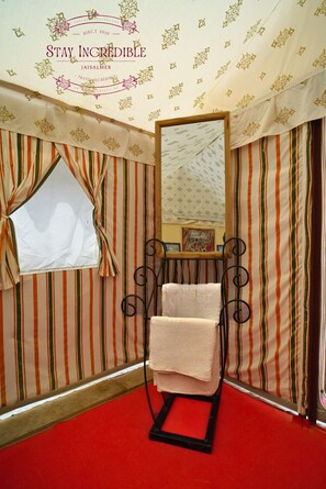 A room with striped wallpaper, a red carpet, a mirror, and a towel rack. - Stay Incredible Camp (Jaisalmer)