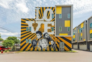 A modern building with a large mural on the side featuring the word "LOVE" and various portraits. - Nashville rooftop fire pit house with ping pong, sleeps 12 near Broadway (Nashville)