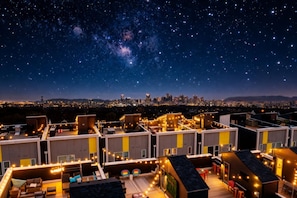 A rooftop terrace with string lights, a city skyline in the background, and a starry night sky. - Nashville music-themed home with game room, sleeps 12 near Nissan Stadium (Nashville)