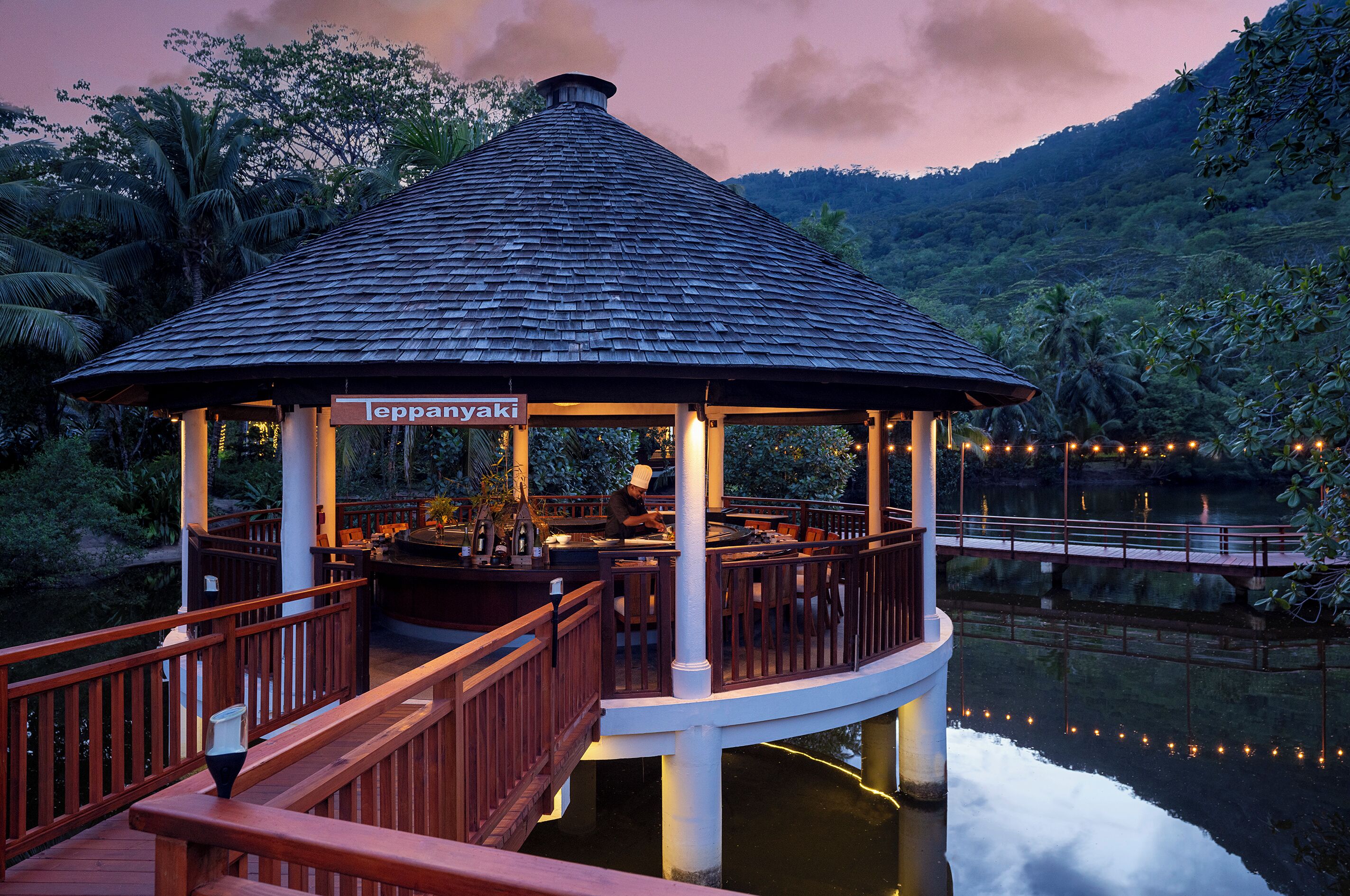 A gazebo with a sign, wooden deck, and a view of a body of water.