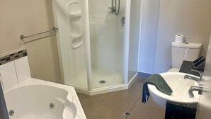A modern bathroom with a glass-enclosed shower, a freestanding bathtub, and a sink with a marble countertop.