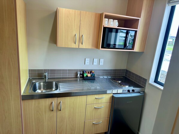 Een minikoelkast, een microgolfoven, een kookplaat