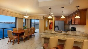 A spacious kitchen with a large island, wooden cabinets, and a view of the water. - 2BR Resort Suite in Orlando w/ Hot Tub in Suite, Resort Pools, & Near Universal (Orlando)