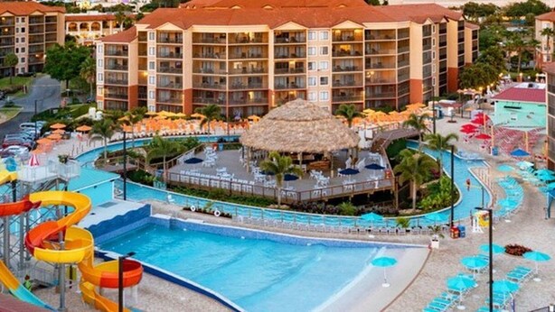 A hotel with a swimming pool, water slides, and a beach area with umbrellas. - 2BR Resort Suite in Orlando w/ Hot Tub in Suite, Resort Pools, & Near Universal (Orlando)
