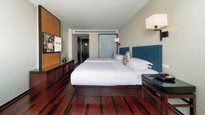 A hotel room with a large bed, a bedside table with a lamp, a wooden floor, and a wall-mounted TV. - SSAW Boutique Hotel Hefei (Hefei)