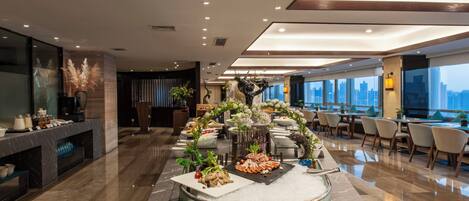 A modern hotel lobby with a sushi bar, seating area, and a view of the cityscape.