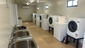 A laundry facility with multiple washing machines and stainless steel sinks. - Discovery Parks Worsktay-Tindal Village (Lansdowne)