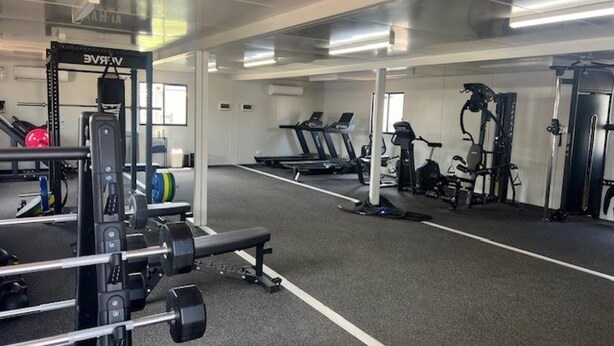 A gym with various exercise equipment including treadmills, stationary bikes, and weight machines. - Discovery Parks Worsktay-Tindal Village (Lansdowne)
