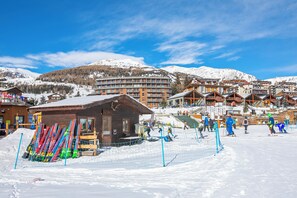 A ski resort with multiple buildings, including a wooden lodge and a multi-story hotel. - Studio Valleverde 26B (Sestriere)