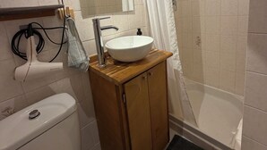 A bathroom with a toilet, sink, and shower.