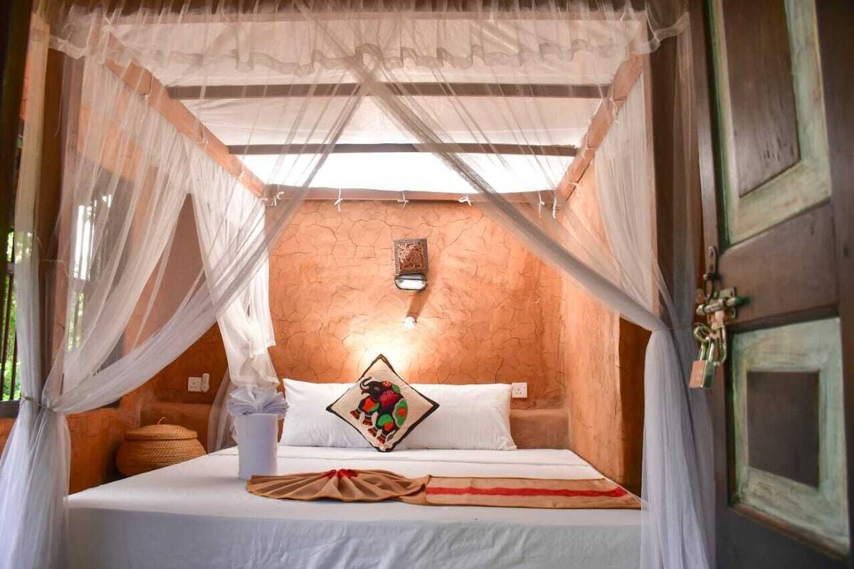 A bed with a canopy, a woven basket, and a decorative pillow.