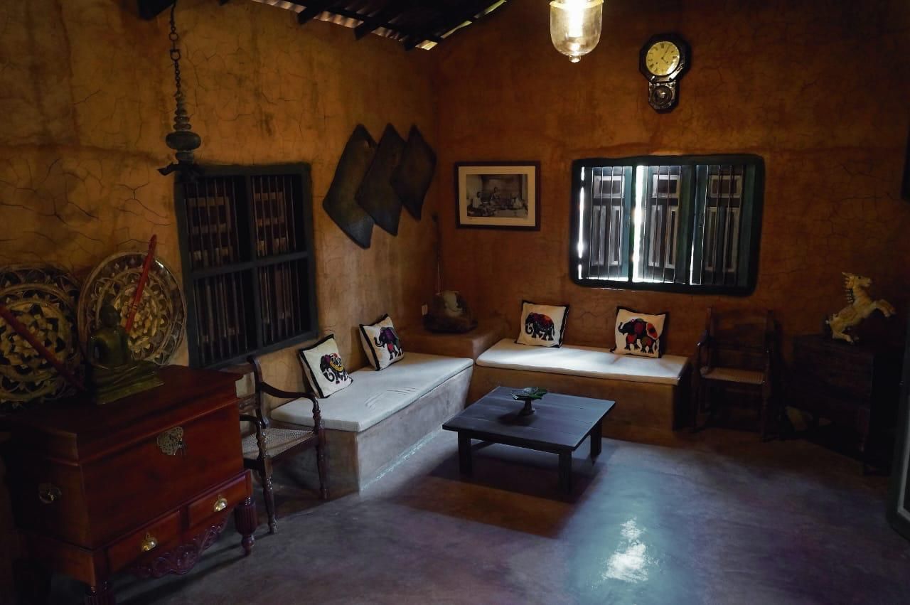 A traditional room with a sofa, a wooden cabinet, a small table, and a window with a view.