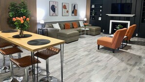 A modern living room with a sofa, chairs, a coffee table, and a TV. - Charming 2-bedroom house in El Centro with WiFi, AC (El Centro)